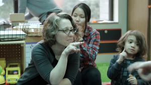 Rosen teacher Pamela Grossman interacts with students during Circle Time. Pam is using American Sign Language (ASL).