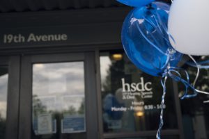 Picture with balloons in foreground and HSDC's entrance in the background.
