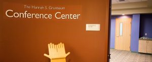 Picture of door to Hannah S. Grunbaum Conference Center, with an ASL hands pedestal.