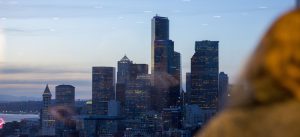 A person at Pacific Tower looking out a window at the Seattle skyline. Taken during HSDC's Cocktails & Connections event.